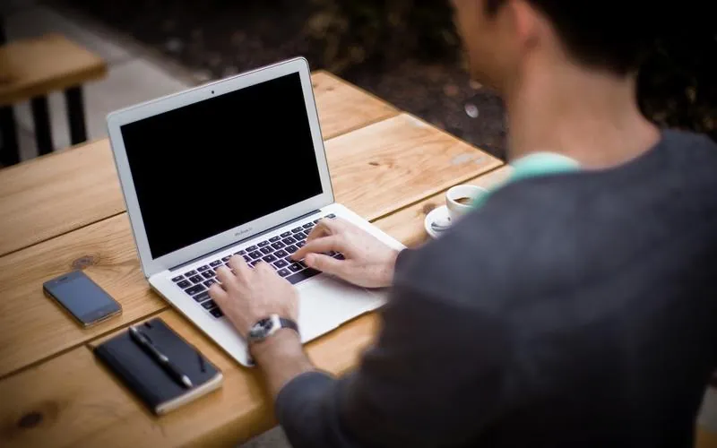 Hands drafting a contract on a laptop